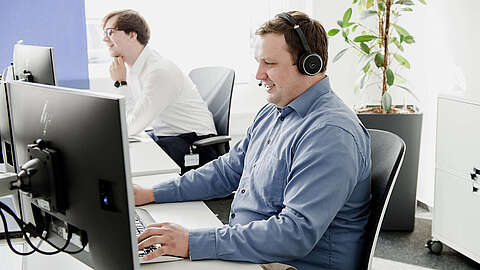 Was ist ein IT Service Desk? Mitarbeiter am Service Desk telefoniert mit einem Kunden