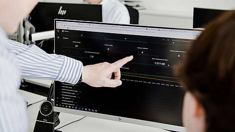Die Herausforderungen beim IT Rollout Person tippt auf einen PC-Bildschirm mit verschiedenen Kennzahlen