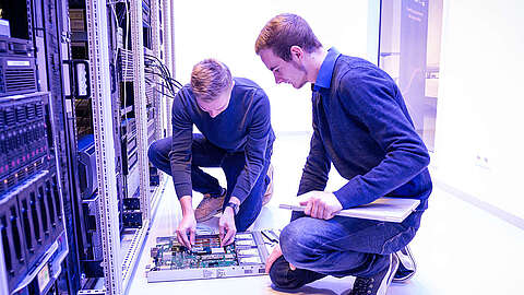 Zwei Techniker arbeiten an einem Serverschrank