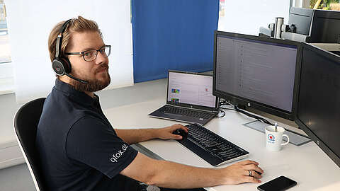 Vom Sandwich Artist zum IT System Engineer LEITDESK-Mitarbeiter sitzt mit Headset an seinem PC-Arbeitsplatz